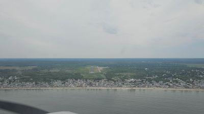 Aerial view of a coastal town with a beach and a small runway.
