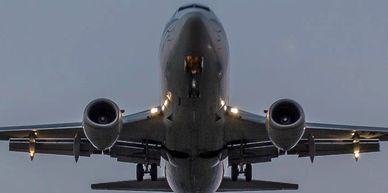 Front view of a commercial airplane in flight during dusk.