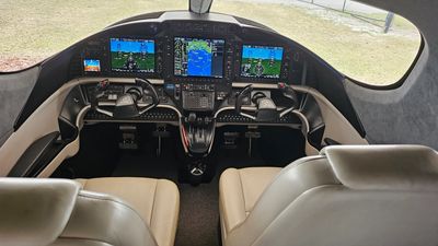 Cockpit of a small aircraft with dual controls and digital displays.
